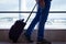 Man on blue jeans walking with carry on luggage at Las Palmas airport terminal