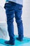 man in blue pants peeing in toilet, rear view