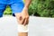 Man with blue runing shorts use hands hold on his knee after running on road in morning time with copy space for text or design