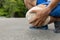 Man with blue runing shorts use hands hold on his knee after running on road in morning time with copy space for text or design