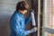 Man in a blue shirt does window installation. Using a mounting foam