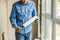 Man in a blue shirt does window installation. Using a mounting foam