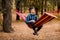 Man in blue shirt relax in hammock in forest