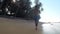Man in blue shorts runs along coastline at endless ocean