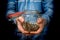 Man in blue sweatshirt holding money jar with coins