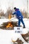 A man in a blue uniform pours gasoline from a canister into the fire. Open fire warning. A sign with the text No fire.