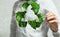 A man on blurred background using volumetric green recycling sign 3d  digital