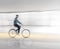 Man in blurred motion cycling along wet road