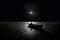 Man in boat swimming in sea during full moon illustration