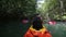 man boating in canoe along lagoon in shadow of trees