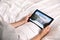 Man booking tickets online in bed, closeup. Travel agency concept