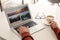 Man booking tickets online on laptop at white table, closeup. Travel agency concept