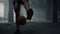 Man bouncing basketball ball between legs. Male player playing basketball