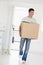 Man with box moving into new home smiling