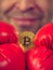 Man in boxing gloves holding bitcoin