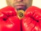 Man in boxing gloves holding bitcoin