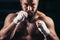 Man boxing workout on ring. Caucasian male boxer in black gloves