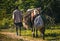 Man and boy accompany horse with goods along road in rural Haiti.