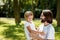 Man and boy in white t shirts. Man with dark hair is holding a boy with blonde hair in his arms boy. Both of them are