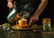 A man brews tea with medicinal herbs on the kitchen table. Traditional medicine concept at home. Adding boiling water to a mug