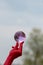 Man with bright red balances purple tinged glass sphere