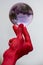 Man with bright red hand holds up purple glass sphere