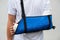 Man with broken arm wrapped medical cast plaster and blue bandage. Fiberglass cast covering the wrist, arm, elbow after sport