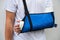 Man with broken arm wrapped medical cast plaster and blue bandage. Fiberglass cast covering the wrist, arm, elbow after sport