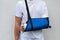 Man with broken arm wrapped medical cast plaster and blue bandage. Fiberglass cast covering the wrist, arm, elbow after sport