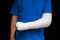 Man with broken arm wrapped medical cast plaster. Fiberglass cast covering the wrist, arm, elbow after sport accident, isolated on