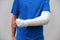 Man with broken arm wrapped medical cast plaster. Fiberglass cast covering the wrist, arm, elbow after sport accident, isolated on