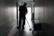 Man with broom cleaning office corridor