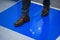 Man in brown shoes stepping on blue Adhesive Sticky Mats