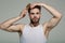 Man brush hair with hairbrush on grey background