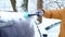 A man brushes snow from a car after a snowfall. A hand in a mustard jacket with a car broom on the white body. Winter weather cond