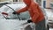 Man brushes snow from a car in winter