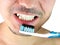 Man, brushing teeth with a blue tooth brush