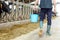 Man with bucket walking in cowshed on dairy farm