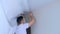 Man builder making demontage of stretch suspended ceiling cuts it using knife.