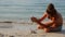 A man builds a sand castle on the seashore