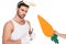 Man with bunny ears holding cutlery while female hand holding carrot beside