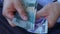 A man in a business shirt counting Indonesian Rupiah money. Various banknotes