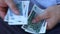 A man in a business shirt counting Myanmar money. Various banknotes