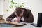 A man in a business suit fell asleep at a desk