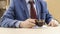 A man in a business suit holds a cup of hot coffee in his hands. Morning businessman. Close-up