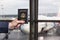 Man businessman  in a blue suit holding american passport with  in the airport waiting zone looking through the window at planes