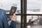 Man businessman  in a blue suit  holding american passport with boarding pass in the airport waiting zone looking through the