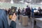 Man businessman  in a blue suit with suitcase holding american passport with boarding pass in the airport opposite customs