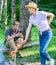 Man busy with smartphone while girl roasting food over fire. Family picnic nature background. Family relaxing at picnic