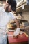 Man in butcher\'s shop preparing food for customer, vertical